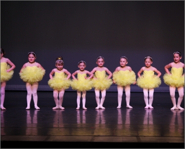 Dancers dressed in yellow in line